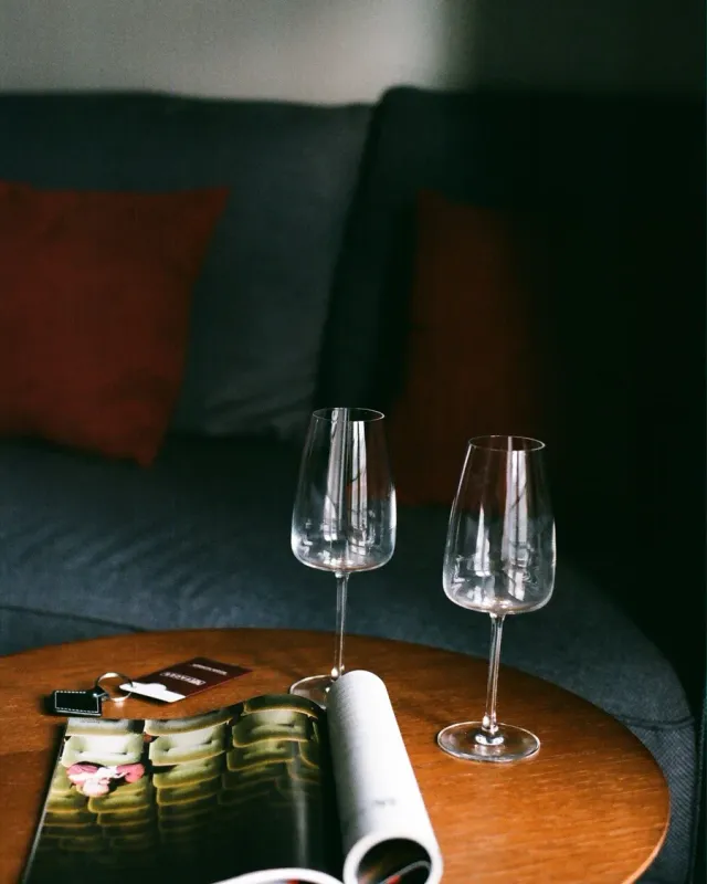 Two wine glasses and an open magazine on a side table
