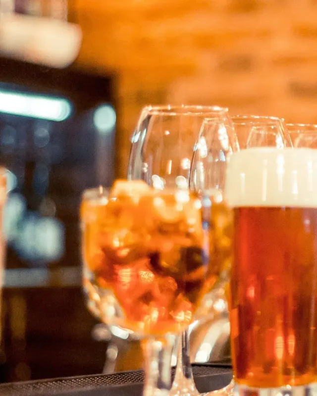 A spritz, a beer and wine glasses on a warm bar